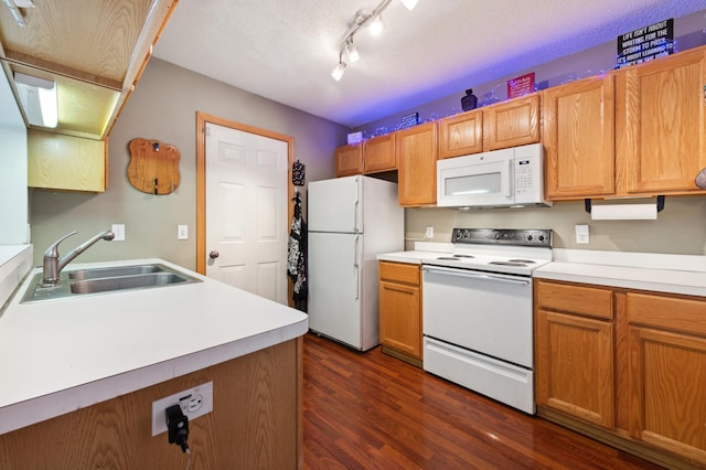 kitchen with a textured ceiling, white appliances, dark wood-type flooring, and sink