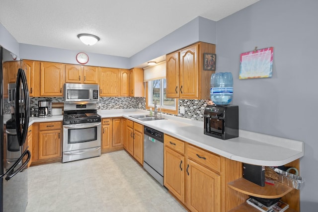 kitchen featuring open shelves, stainless steel appliances, light countertops, decorative backsplash, and a sink