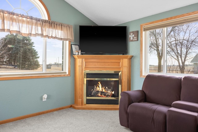 sitting room with vaulted ceiling, a glass covered fireplace, carpet flooring, and baseboards