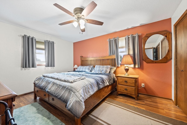 bedroom featuring ceiling fan, baseboards, and wood finished floors