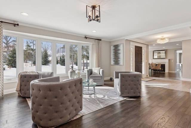 living room featuring an inviting chandelier, crown molding, and dark wood-type flooring