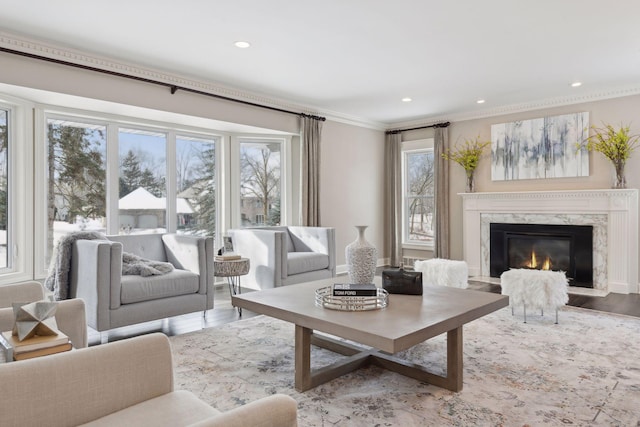 living room featuring crown molding, a premium fireplace, and light hardwood / wood-style flooring