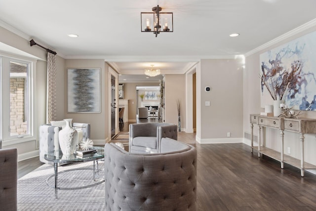 living area with an inviting chandelier, ornamental molding, and dark wood-type flooring