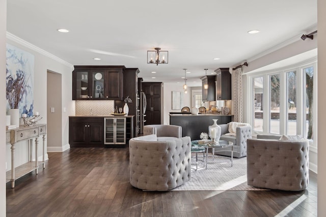 living room with wine cooler, sink, dark hardwood / wood-style flooring, and ornamental molding