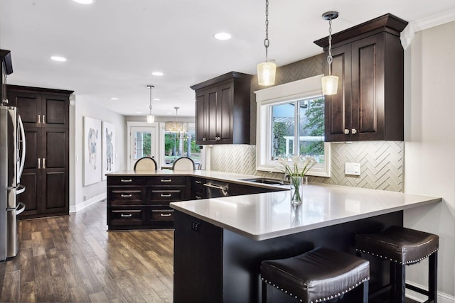 kitchen featuring decorative light fixtures, a kitchen breakfast bar, and kitchen peninsula