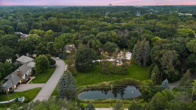 aerial view at dusk featuring a water view