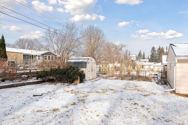 yard layered in snow with a storage shed