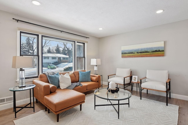 living room with a textured ceiling and light hardwood / wood-style flooring