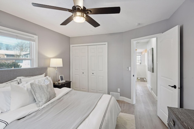 bedroom featuring light hardwood / wood-style flooring, a closet, and ceiling fan