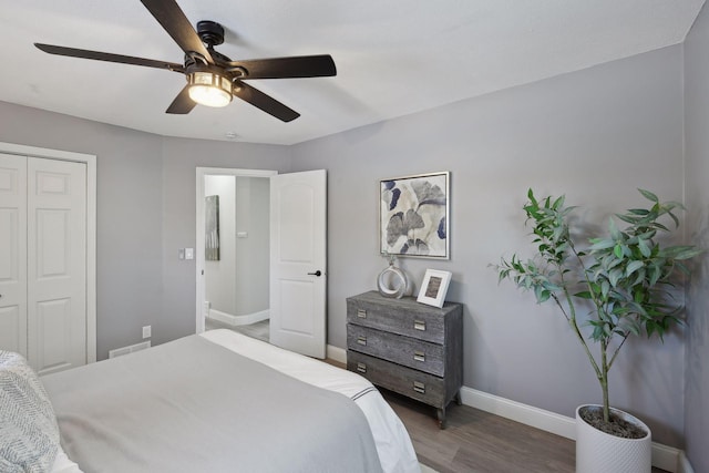 bedroom with dark wood-type flooring, a closet, and ceiling fan