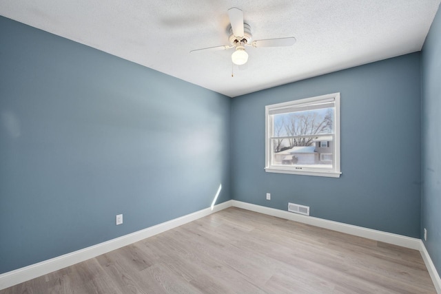 unfurnished room with ceiling fan, light hardwood / wood-style flooring, and a textured ceiling