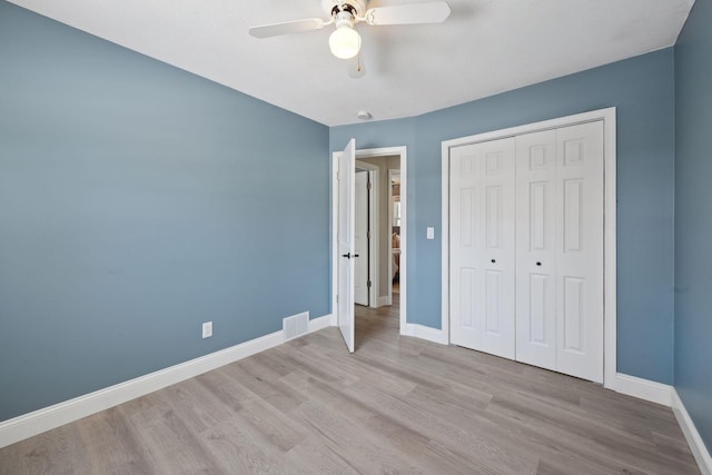 unfurnished bedroom featuring ceiling fan, light hardwood / wood-style floors, and a closet