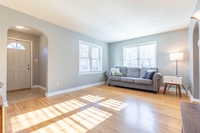 living room featuring a textured ceiling and light hardwood / wood-style flooring