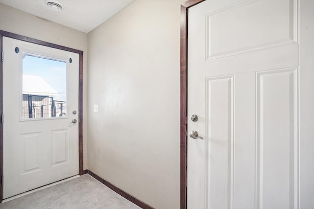 doorway to outside with a textured ceiling