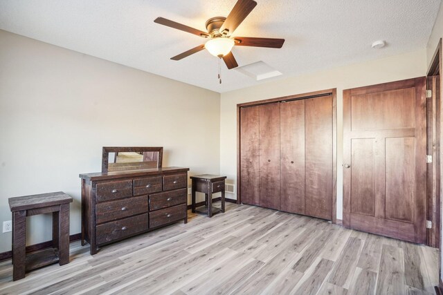 bedroom with a textured ceiling, light wood-type flooring, and ceiling fan