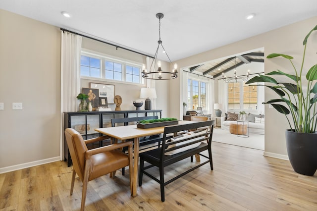 dining room featuring vaulted ceiling with beams, an inviting chandelier, and light wood-type flooring