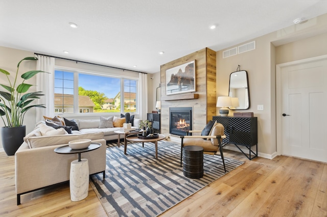 living room with a large fireplace and light hardwood / wood-style floors