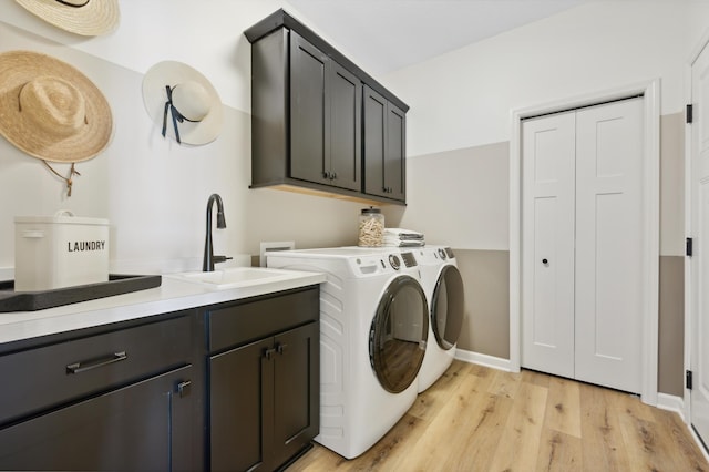 laundry room with cabinets, separate washer and dryer, sink, and light hardwood / wood-style flooring