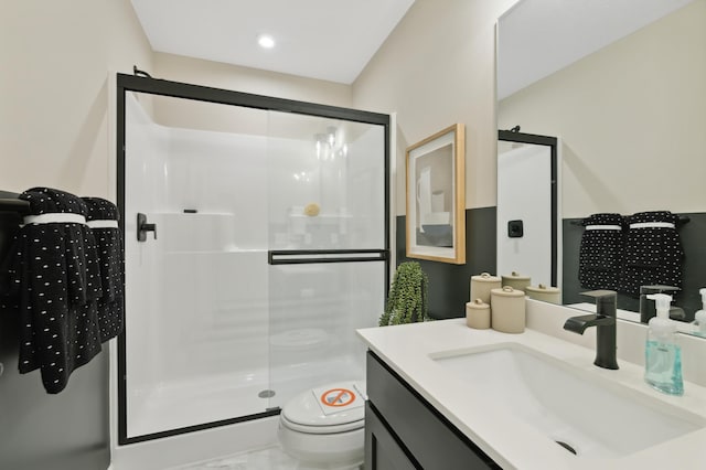 bathroom featuring walk in shower, vanity, and toilet