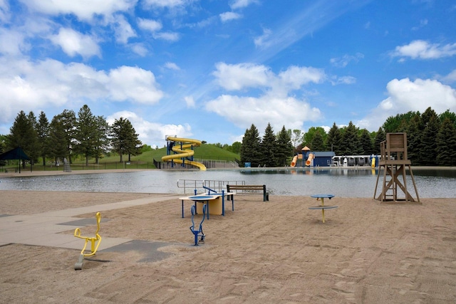 surrounding community featuring a playground and a water view