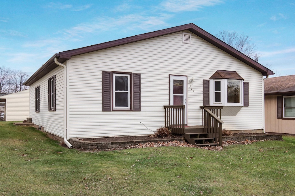 rear view of property featuring a lawn