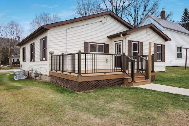 rear view of property featuring a yard and a wooden deck