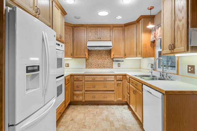 kitchen featuring white appliances, decorative light fixtures, and sink