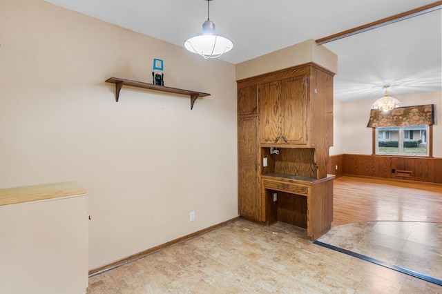 kitchen featuring wooden walls, light hardwood / wood-style flooring, pendant lighting, and fridge