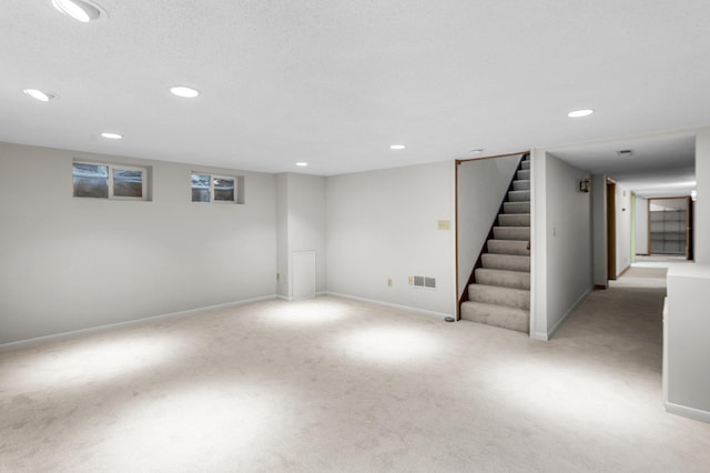 basement featuring light carpet