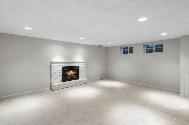 unfurnished living room featuring a fireplace, a textured ceiling, and carpet floors