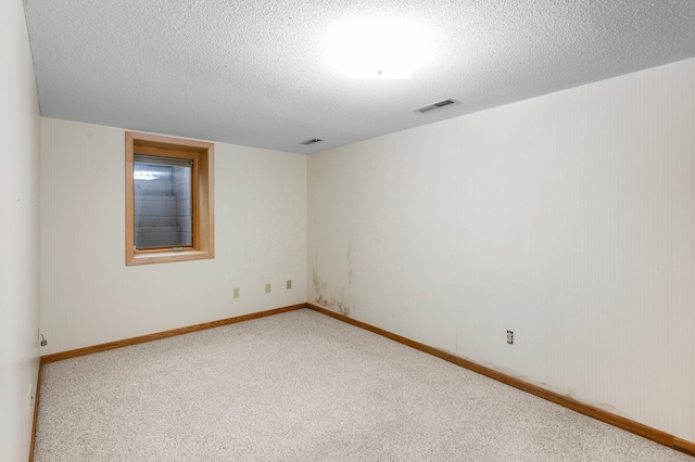 spare room featuring carpet and a textured ceiling