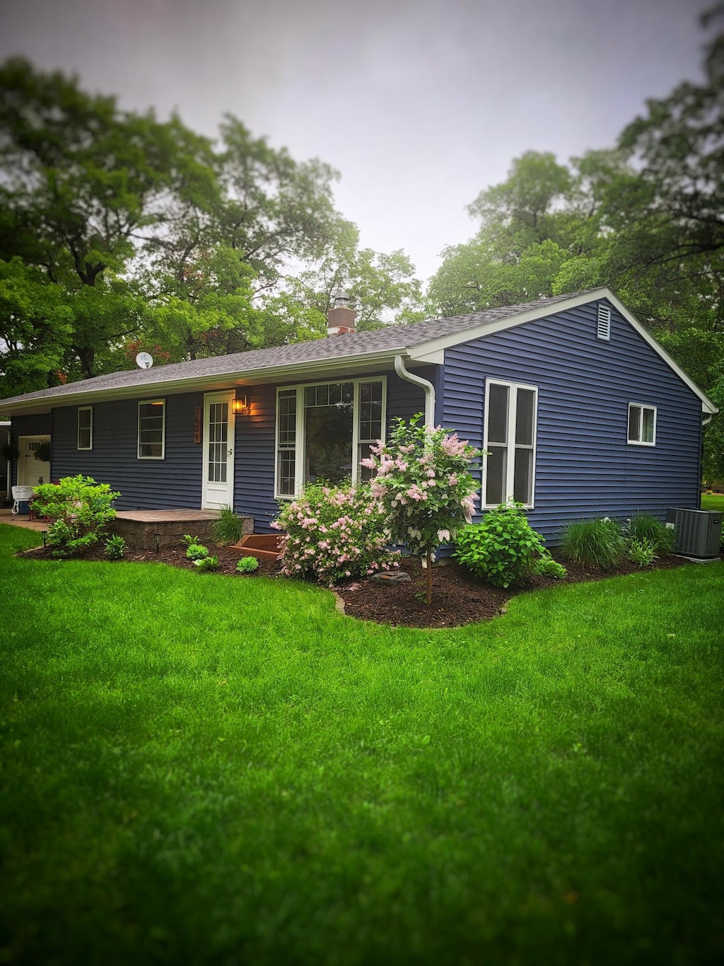 single story home featuring central AC and a front lawn