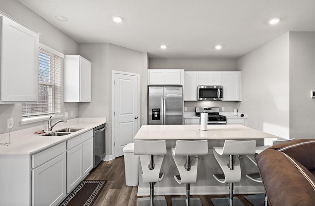 kitchen with dark hardwood / wood-style flooring, white cabinetry, sink, and appliances with stainless steel finishes