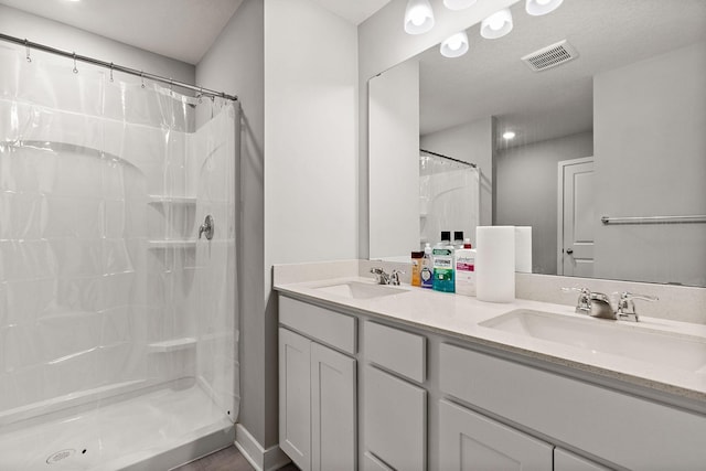 bathroom featuring vanity, a textured ceiling, and a shower with shower curtain