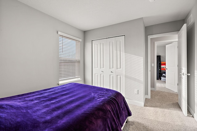 bedroom featuring light colored carpet and a closet