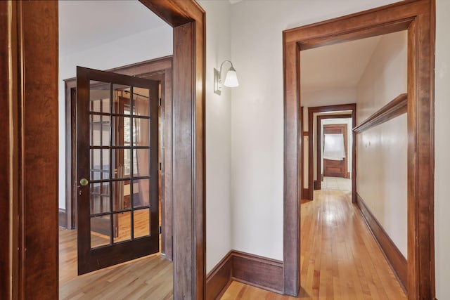 hallway with french doors and light hardwood / wood-style floors