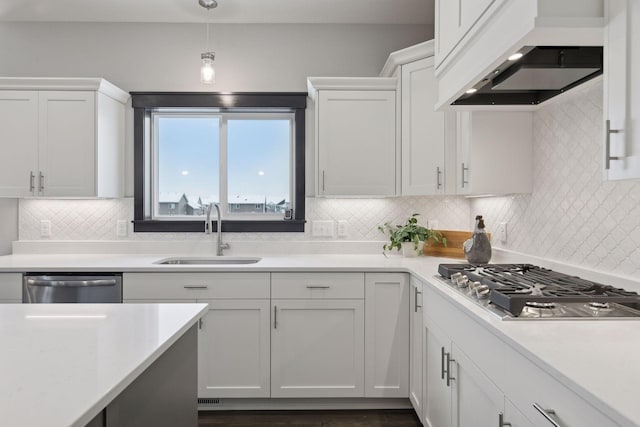 kitchen featuring premium range hood, stainless steel appliances, sink, decorative light fixtures, and white cabinetry