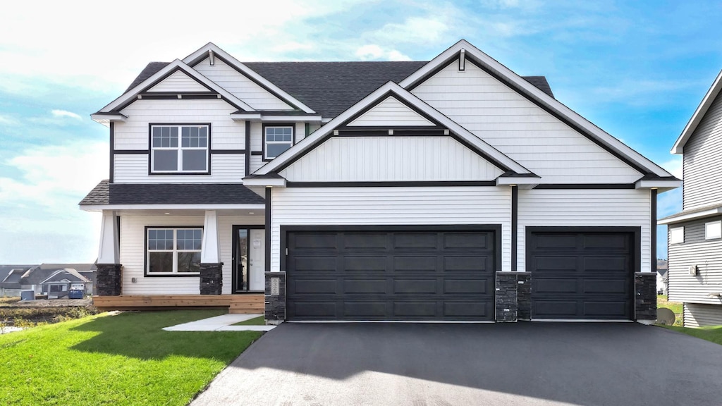 craftsman house featuring a garage and a front lawn