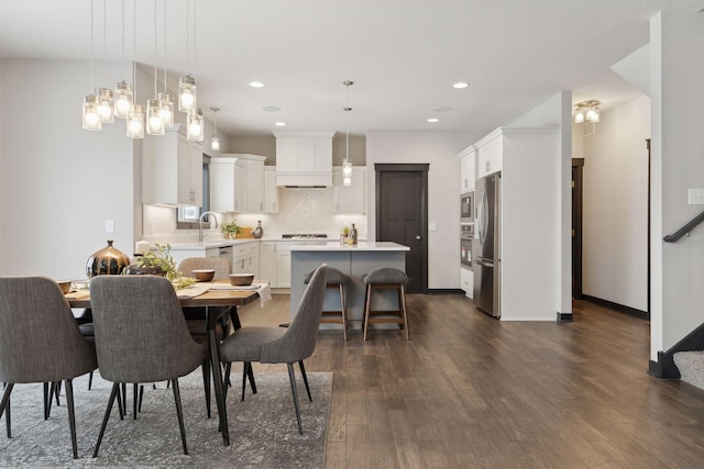 dining area with sink, dark hardwood / wood-style floors, and an inviting chandelier