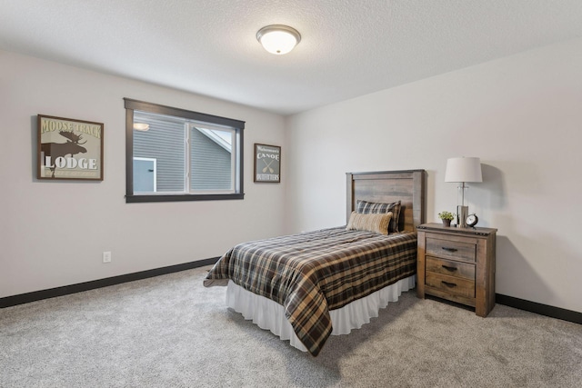 bedroom featuring a textured ceiling and light carpet