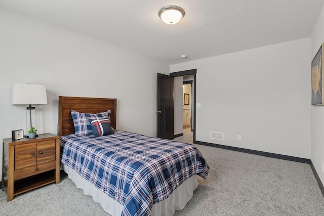 carpeted bedroom featuring a textured ceiling