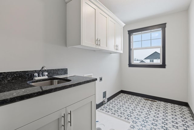 clothes washing area with hookup for an electric dryer, cabinets, and sink