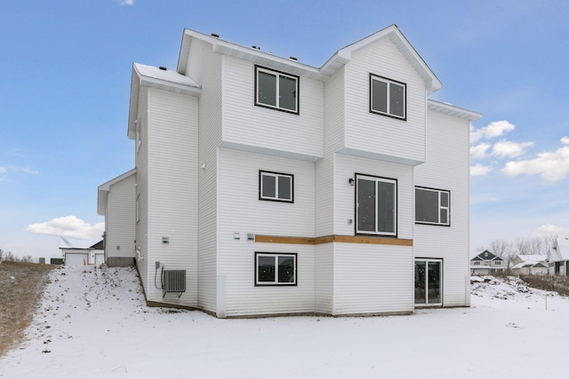 snow covered back of property with cooling unit