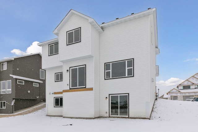 view of snow covered back of property