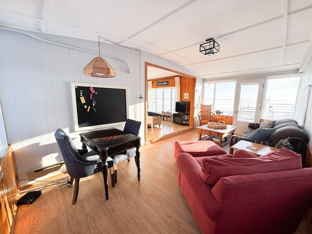 living room with hardwood / wood-style floors, a baseboard heating unit, and wooden walls