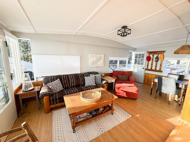 living room with hardwood / wood-style floors, a healthy amount of sunlight, and vaulted ceiling