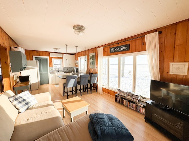 living room featuring light hardwood / wood-style floors and wooden walls