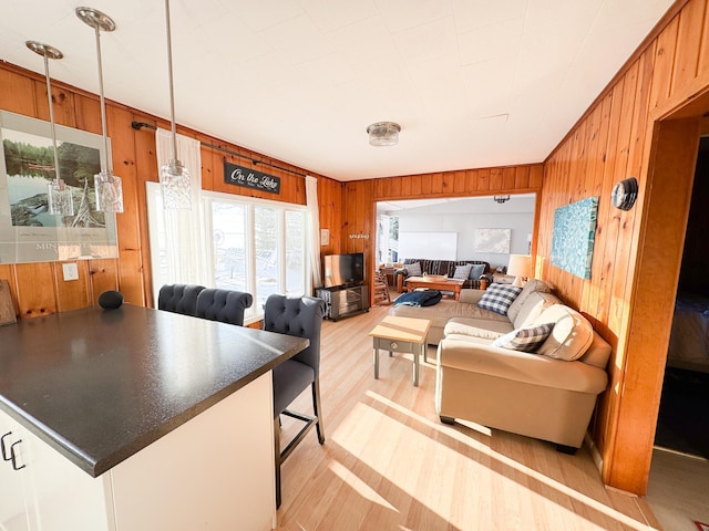 living room featuring light wood-type flooring and wooden walls