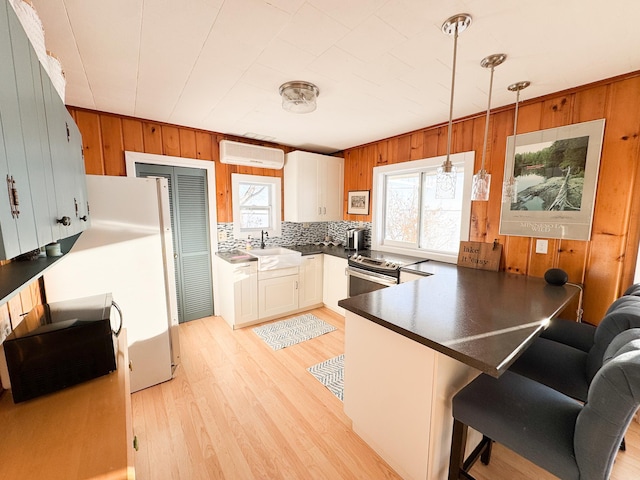 kitchen featuring backsplash, wooden walls, a breakfast bar, and pendant lighting