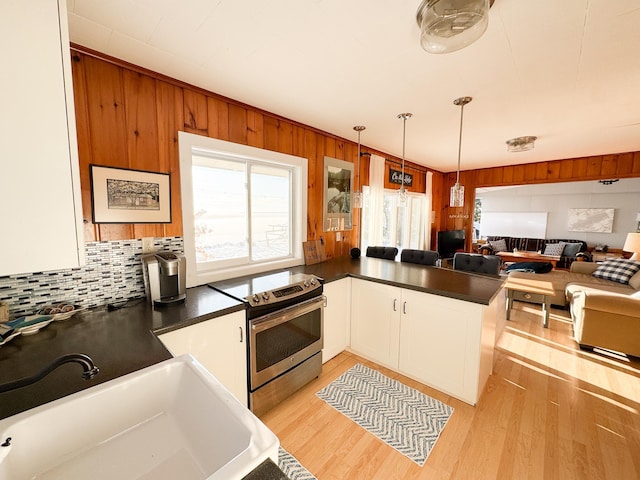 kitchen with white cabinetry, sink, electric range, kitchen peninsula, and decorative light fixtures